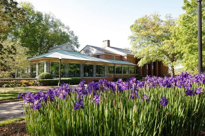 A building on Furman's campus, with purple flowers in the foreground