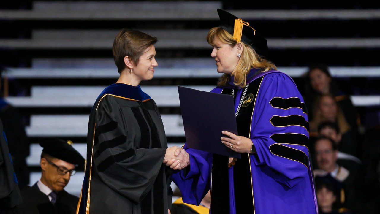 Davis shaking hands with graduating student