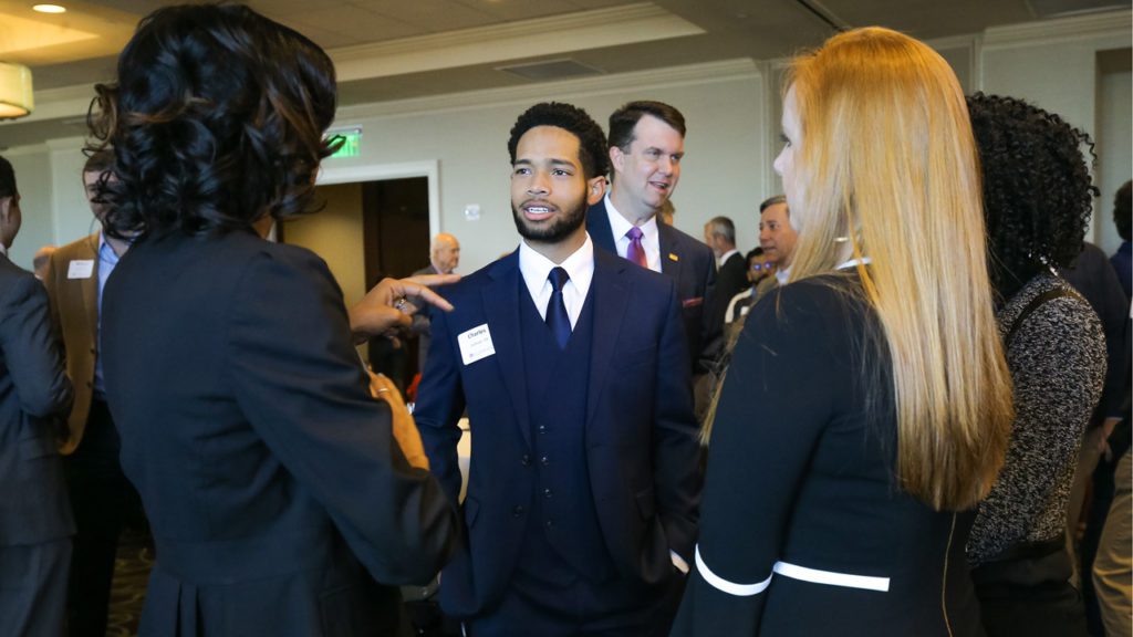 Student listening to mentors at networking event