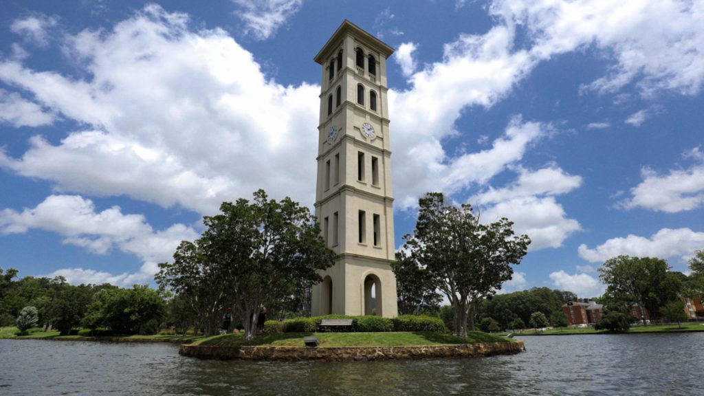 Bell tower on the lake with blue sky behind