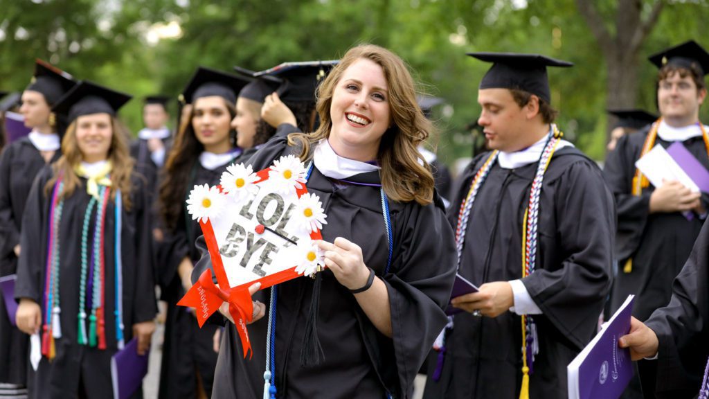 Student displaying her cap with "Lol, bye" on top