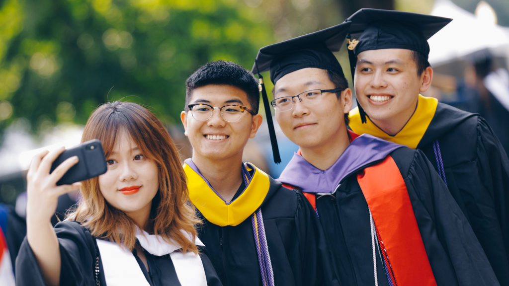 Student taking selfie with gowns on