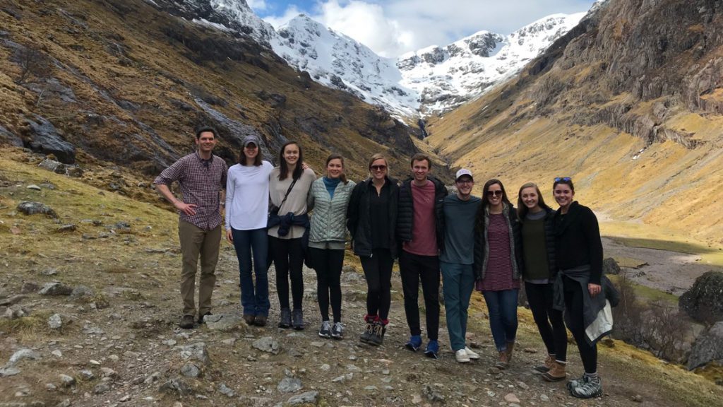 Students standing at the bottom of mountains on international trip