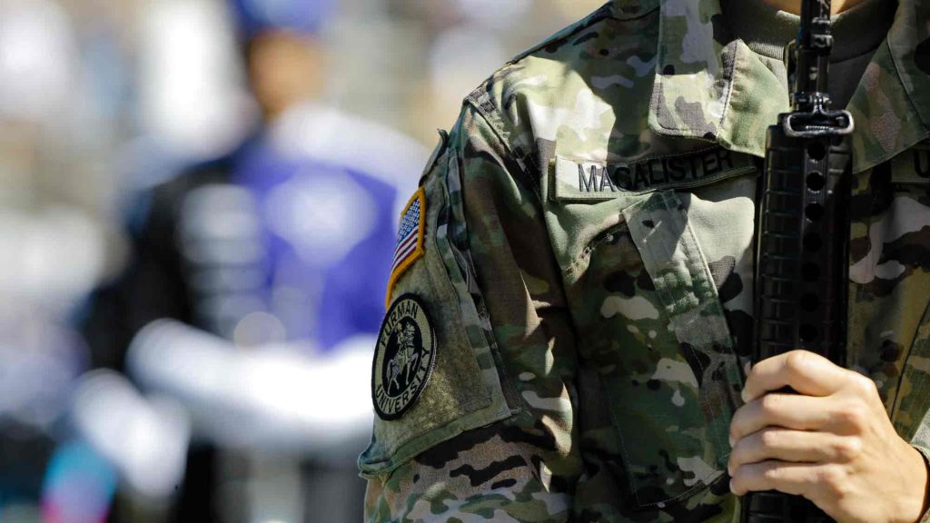 Military uniform close up, man holding gun