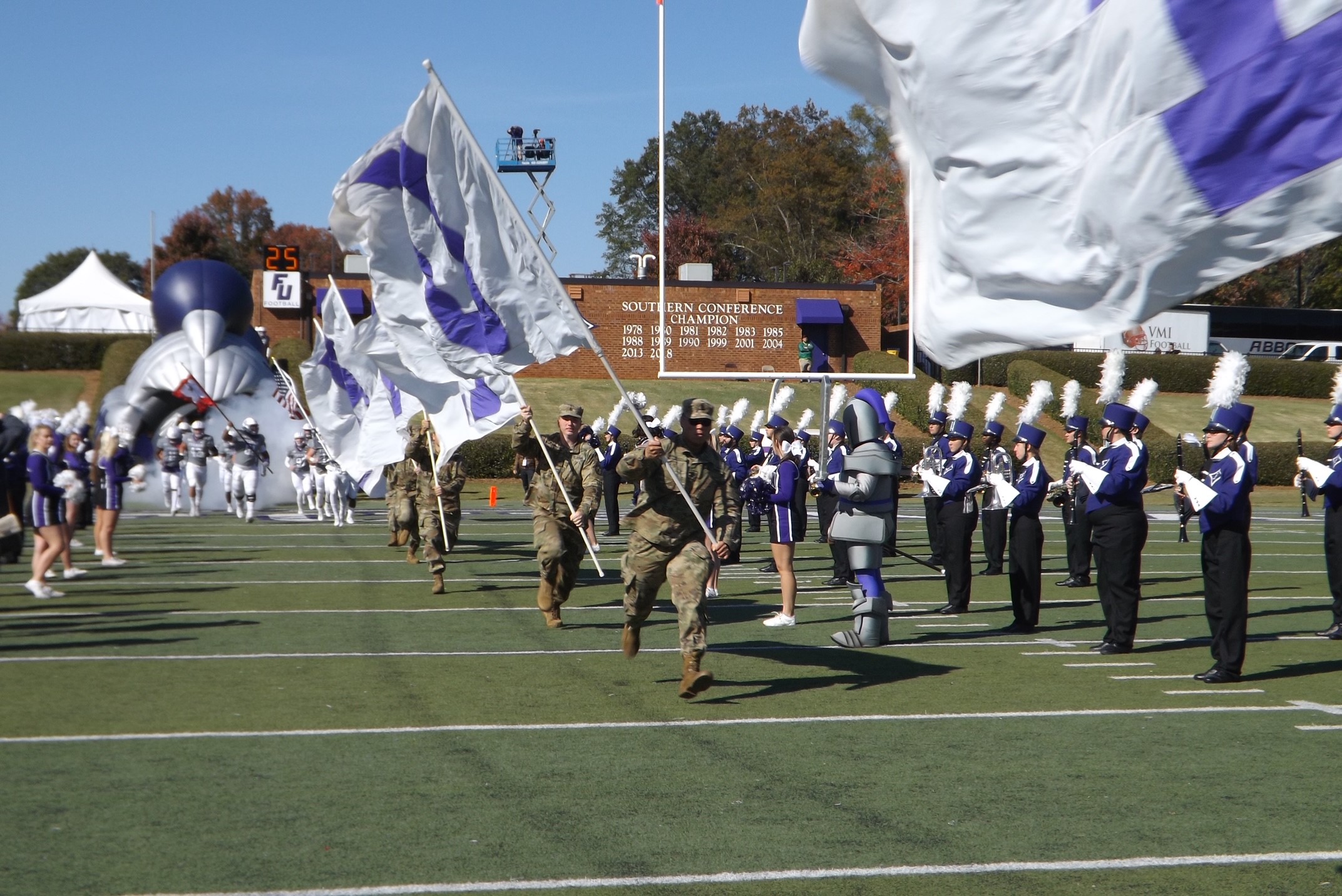 Student cadets carrying flags for football game