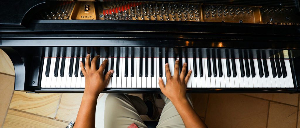 Student playing the piano, aerial view