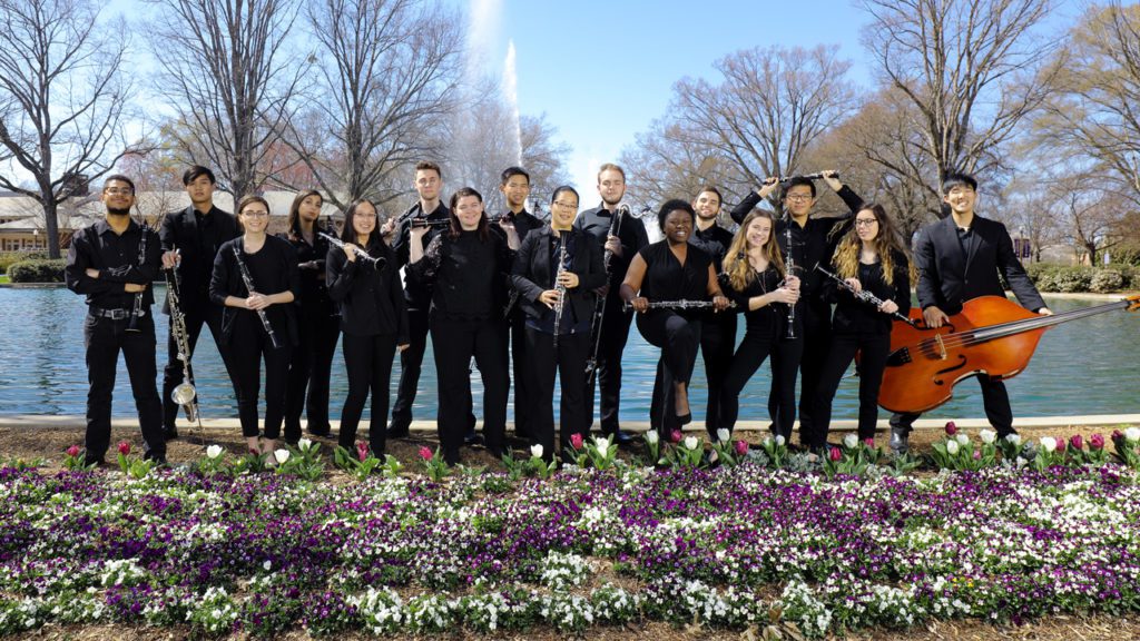 Students standing in front of fountains with their instruments