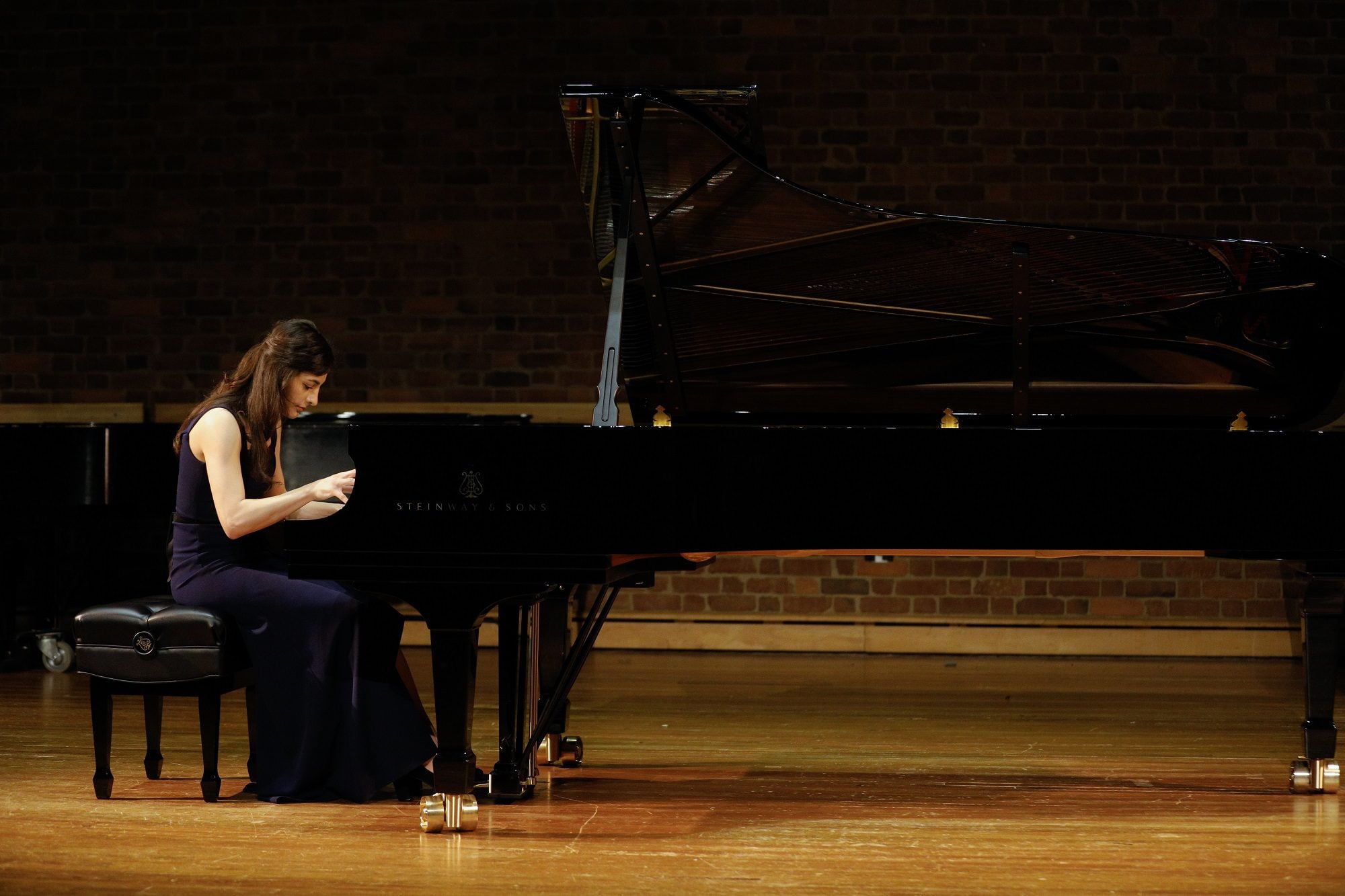 Student playing Steinway piano in recital hall