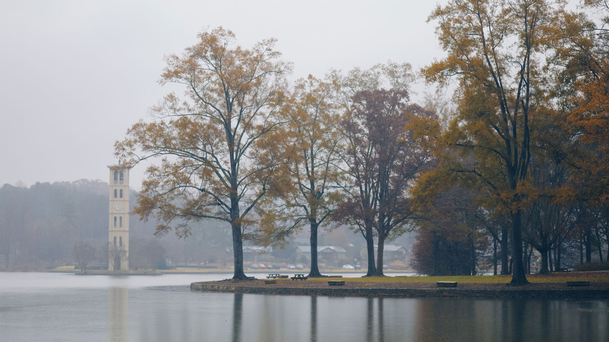 Furman bell tower from afar, fog and mist on the lake