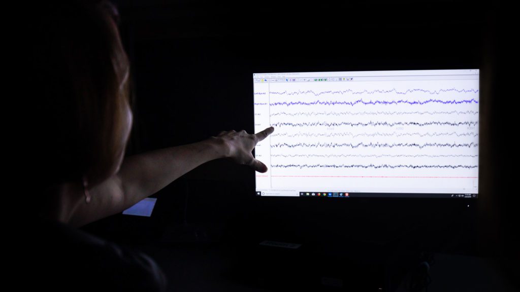 Student reading brain waves on a screen