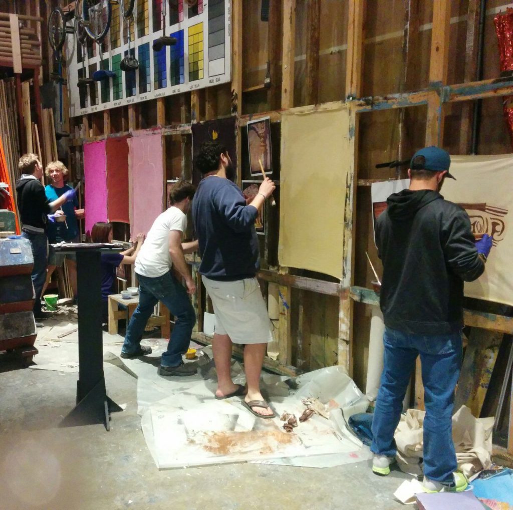 Students painting in the scene shop