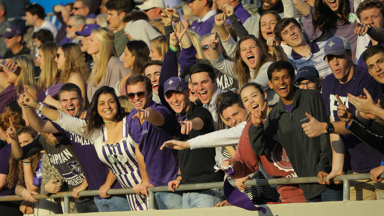 Students waving from the bleachers during a game