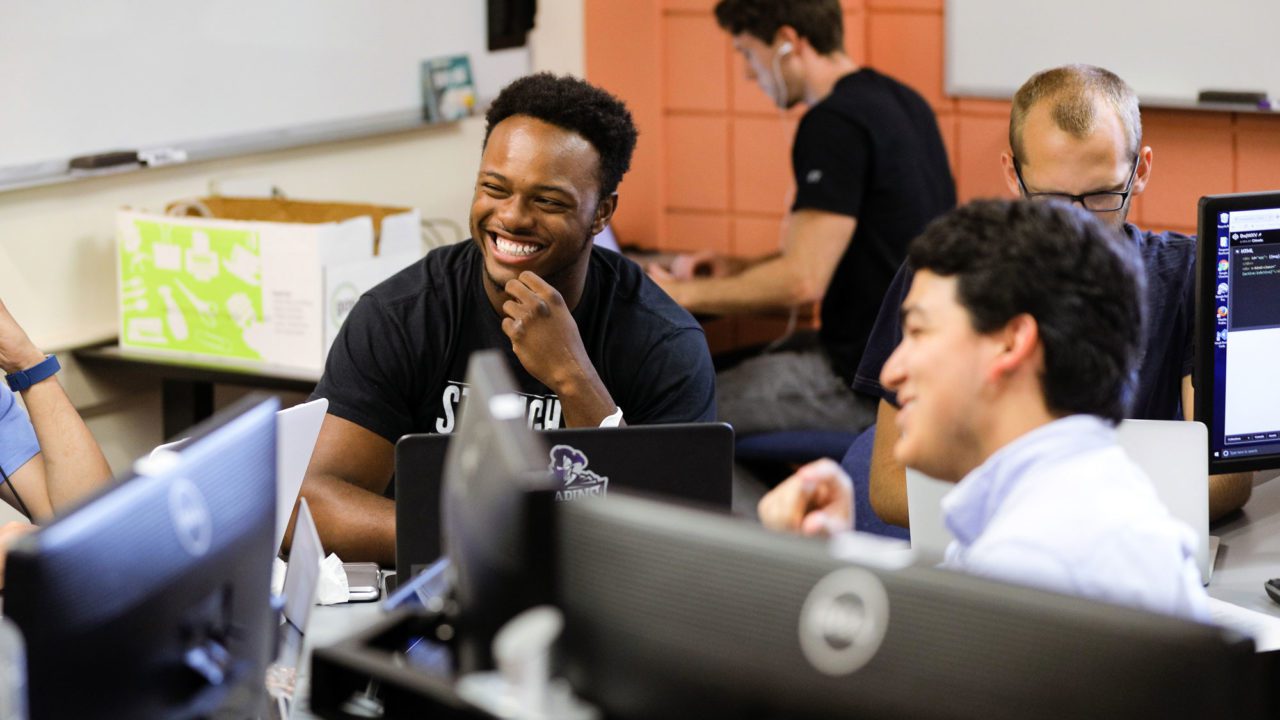 Students smiling during computer science class