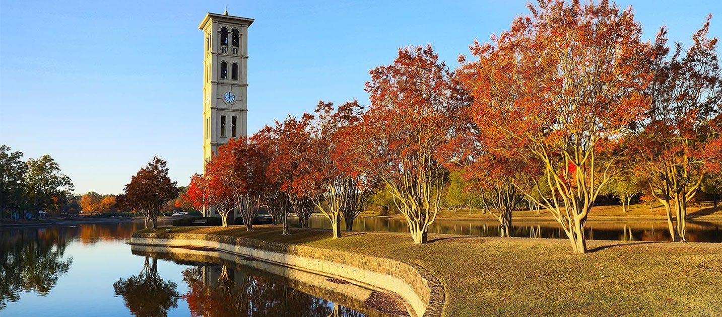 Belltower in fall, autumnal trees reflecting off the lake