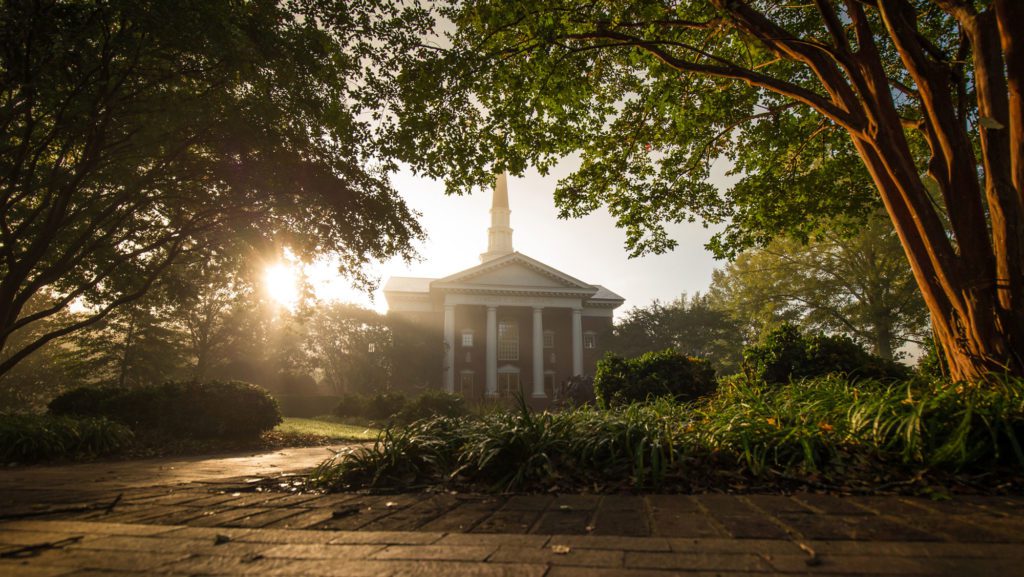 Furman chapel during sunrise, from the trees