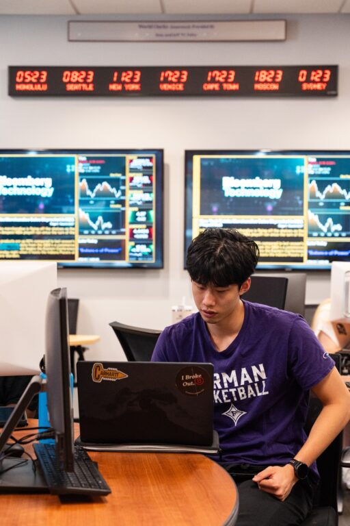 Economics student in class working on his computer