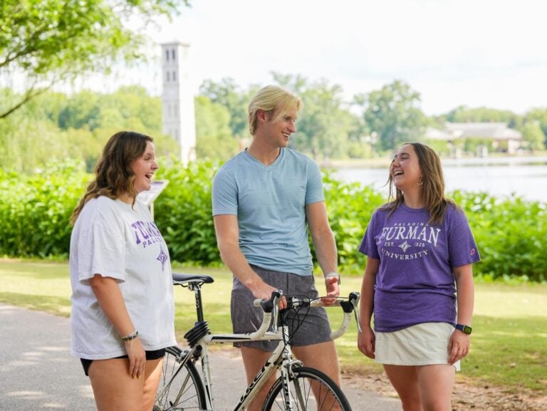 Emma Dixon ’25, Tate Denham ’26, and Lexia Gianopoulos ’26 talk together near Furman Lake on Monday, June 10, 2024.