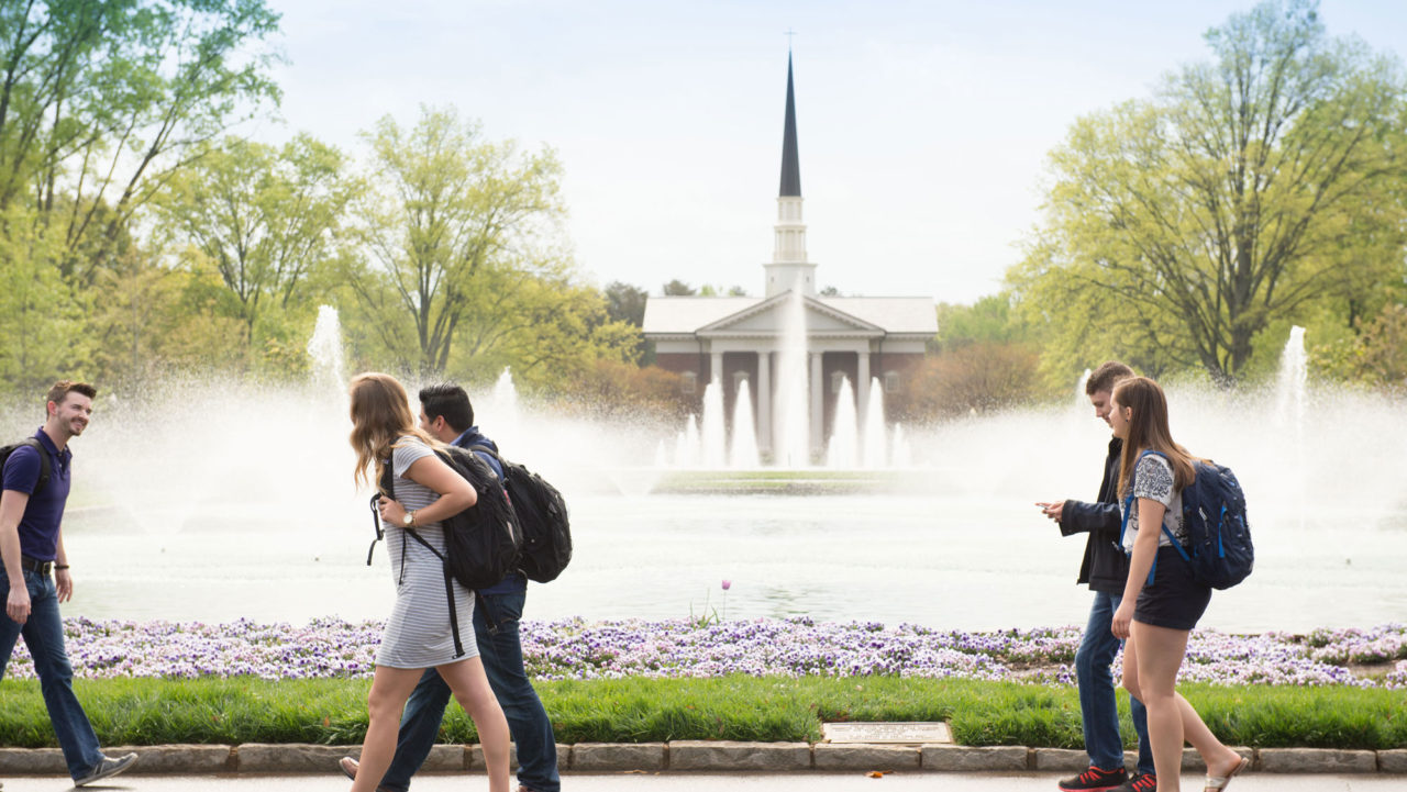 Students walking by fountains in front of the chapel