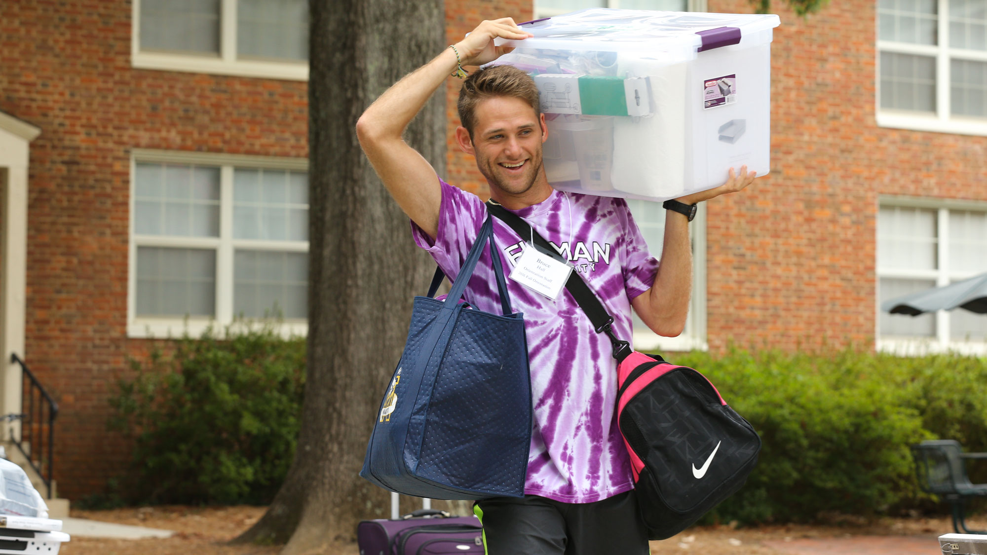 student carrying move in supplies to south housing dorm