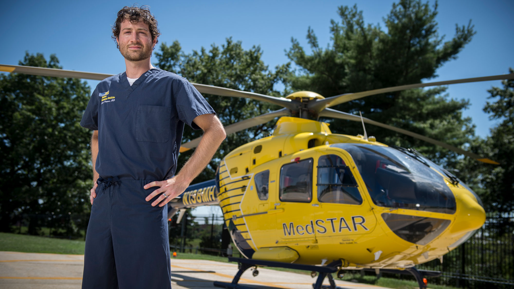Student standing outside of a hospital helicopter in scrubs