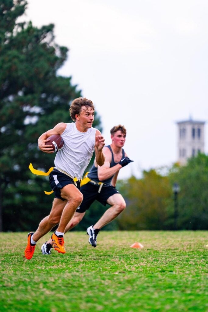 Two students running with ball