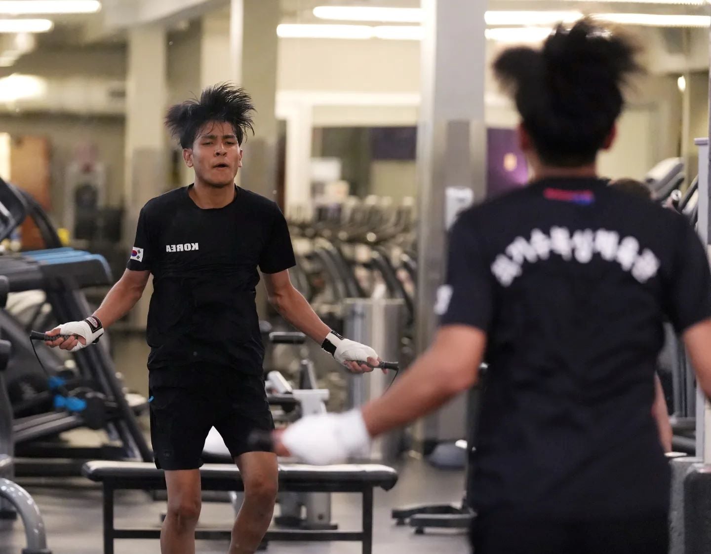 International student jumps rope in front of a mirror.