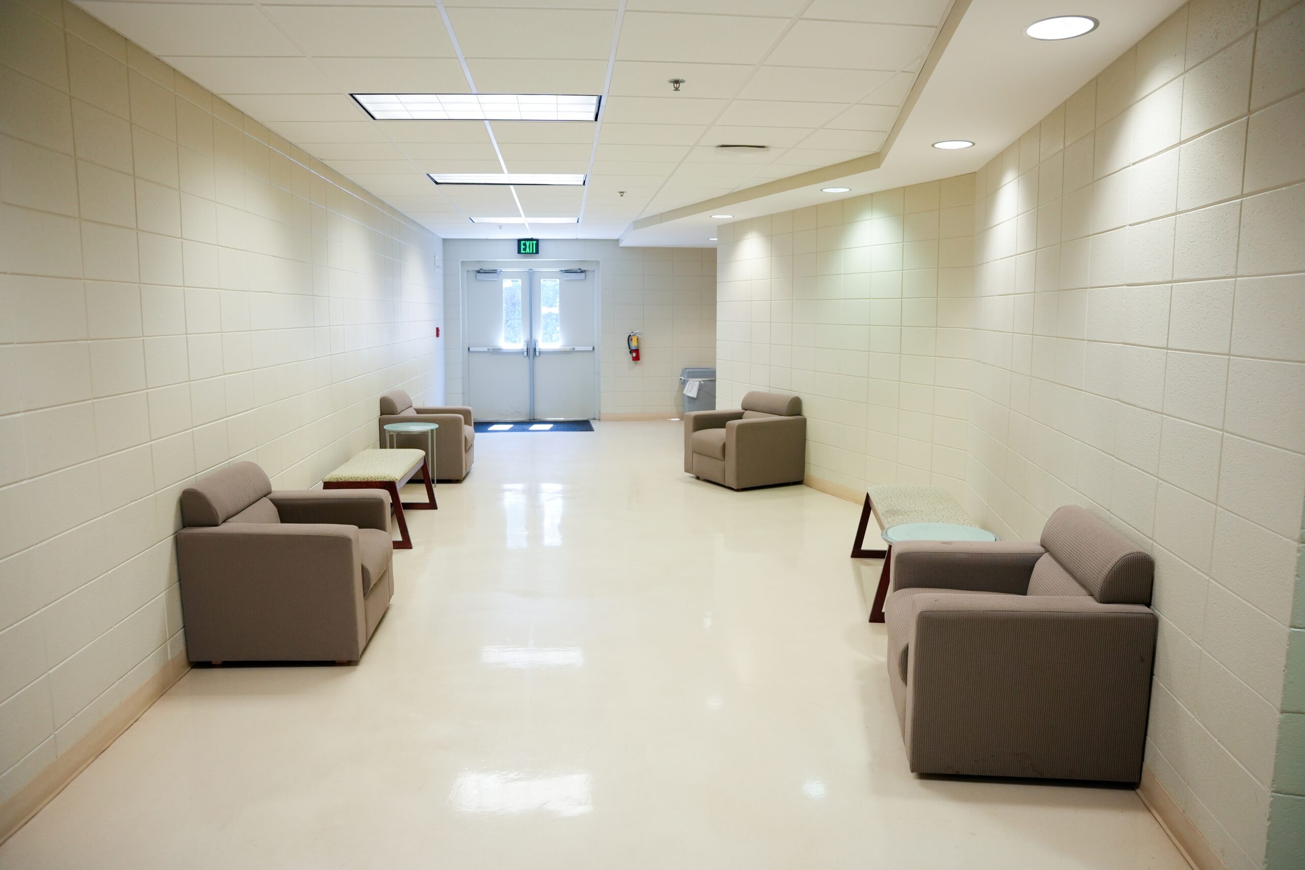 Hallway outside of PAC 113 & 114 is shown with small grouping of furniture.
