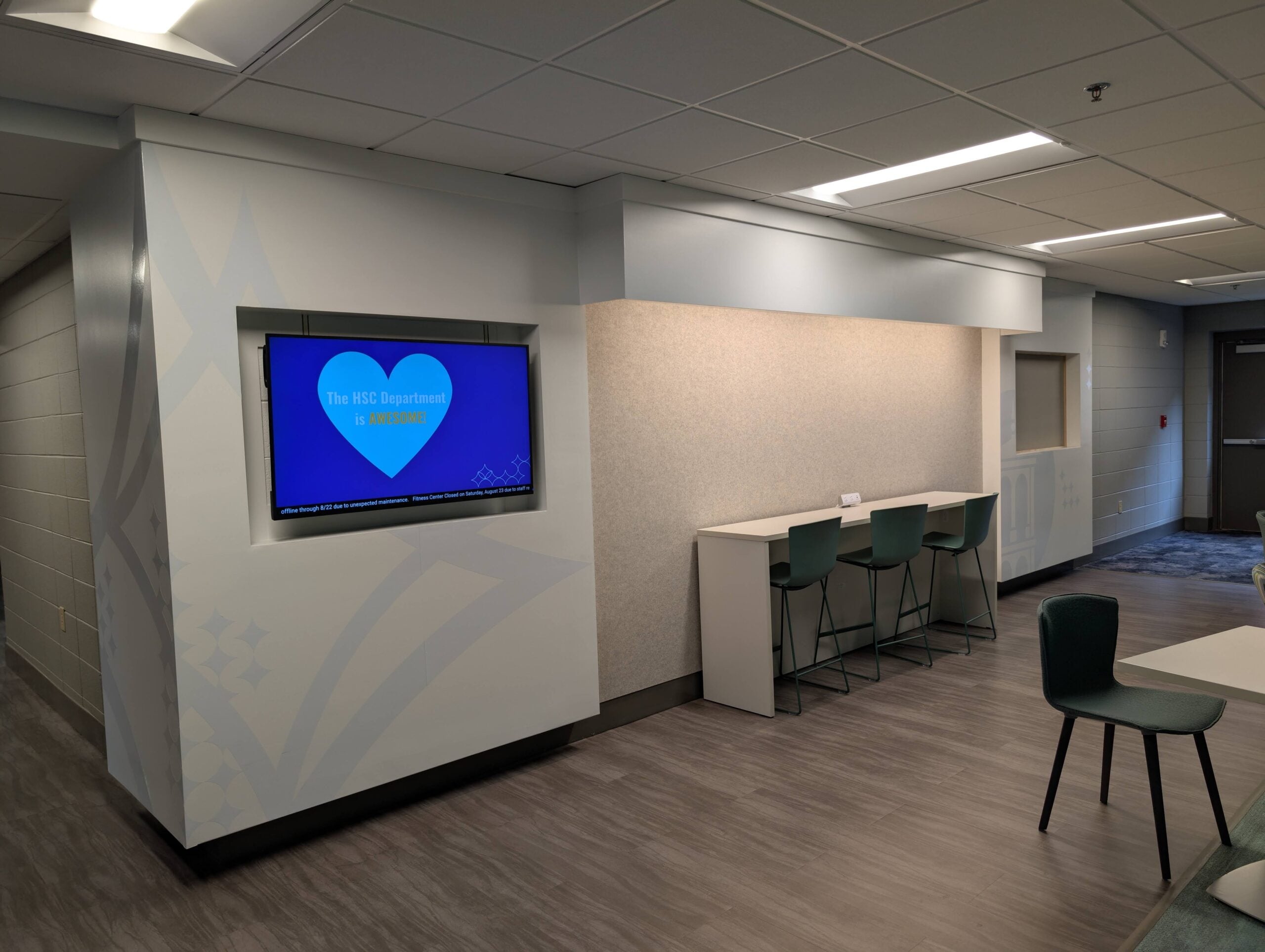 Another digital display board is shown with a slide from Health Sciences