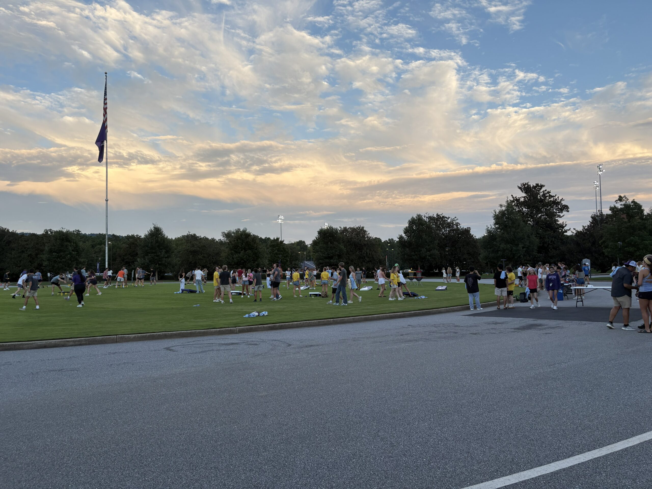 A wide angle shot shows several students exploring and playing out front of the PAC.