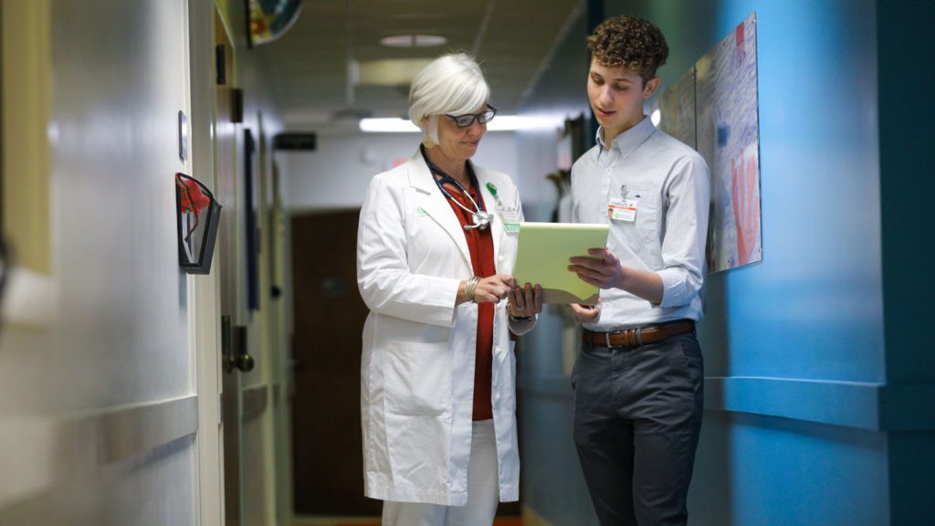 Student analyzing notes with doctor
