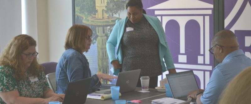 a group of unique individuals are learning around a table, engaging with one another