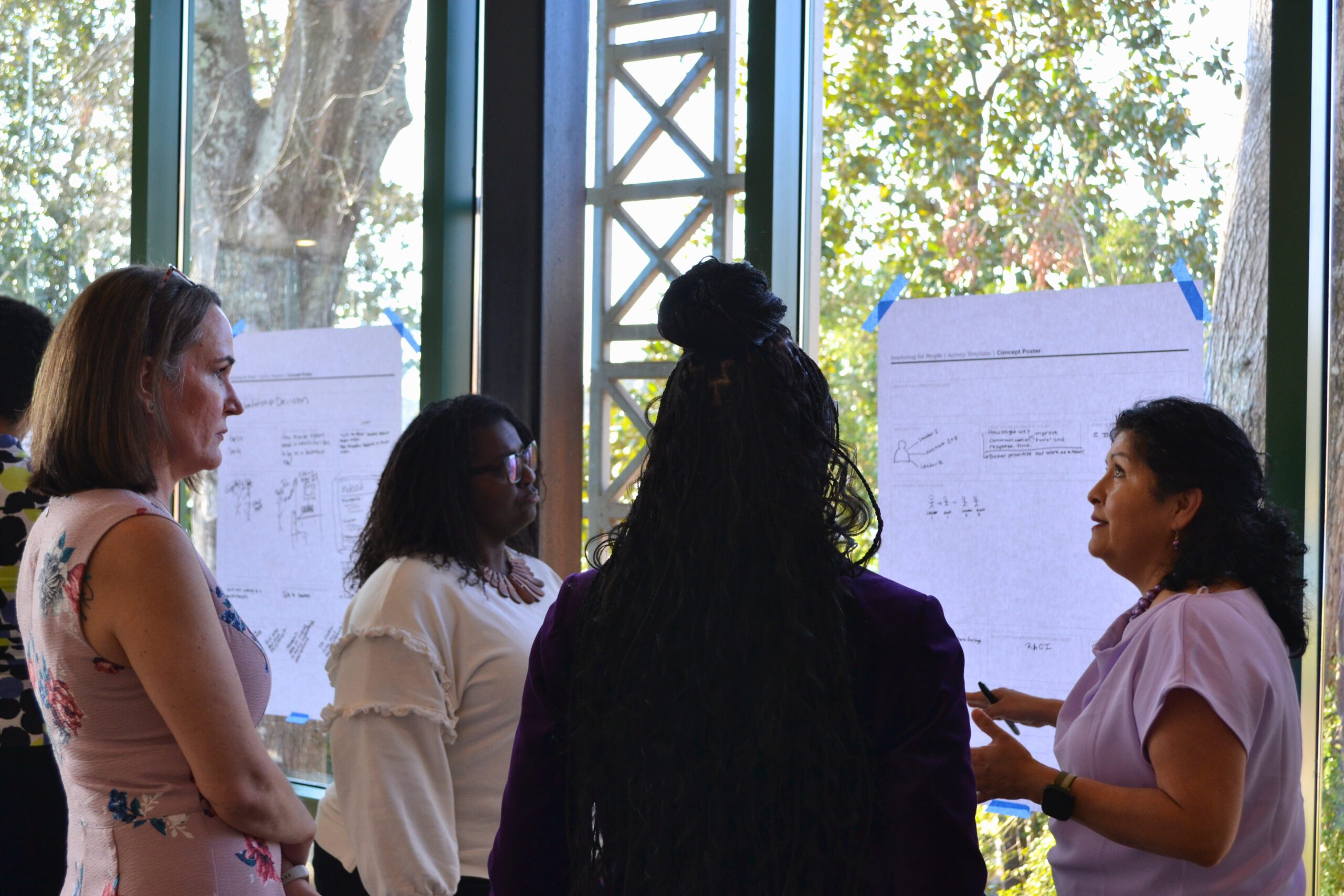 Four members of the Fall 2024 Women's Leadership Initiative discuss on a project.