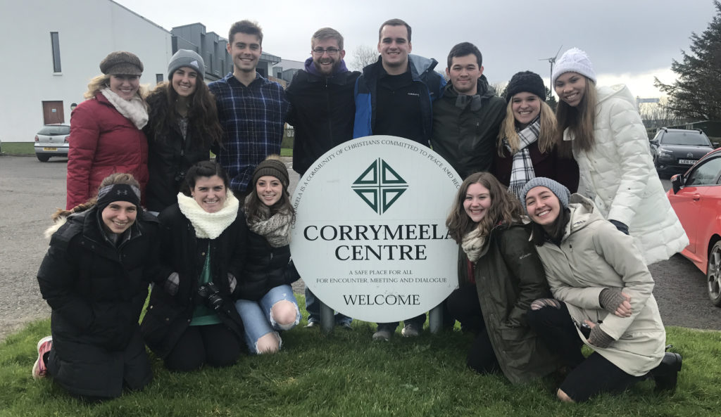 Students gathered around Corrymeela Community sign in Ireland.