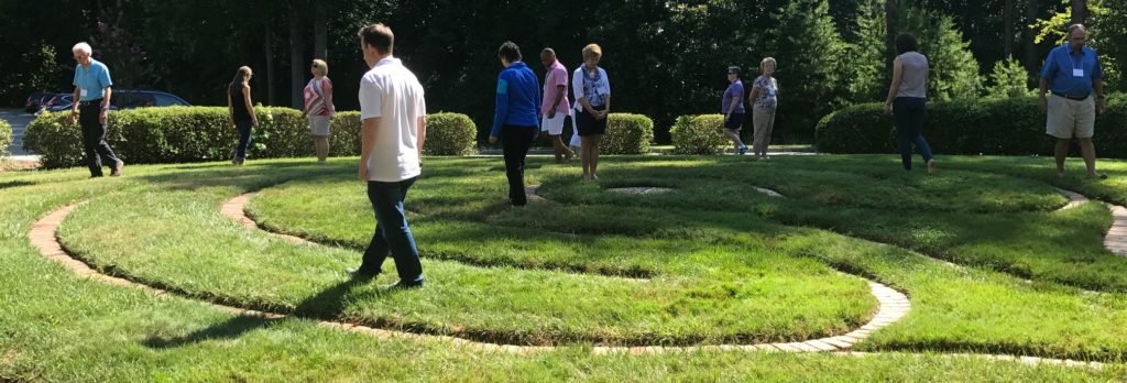 Alumni walking around labyrinth behind Daniel Chapel