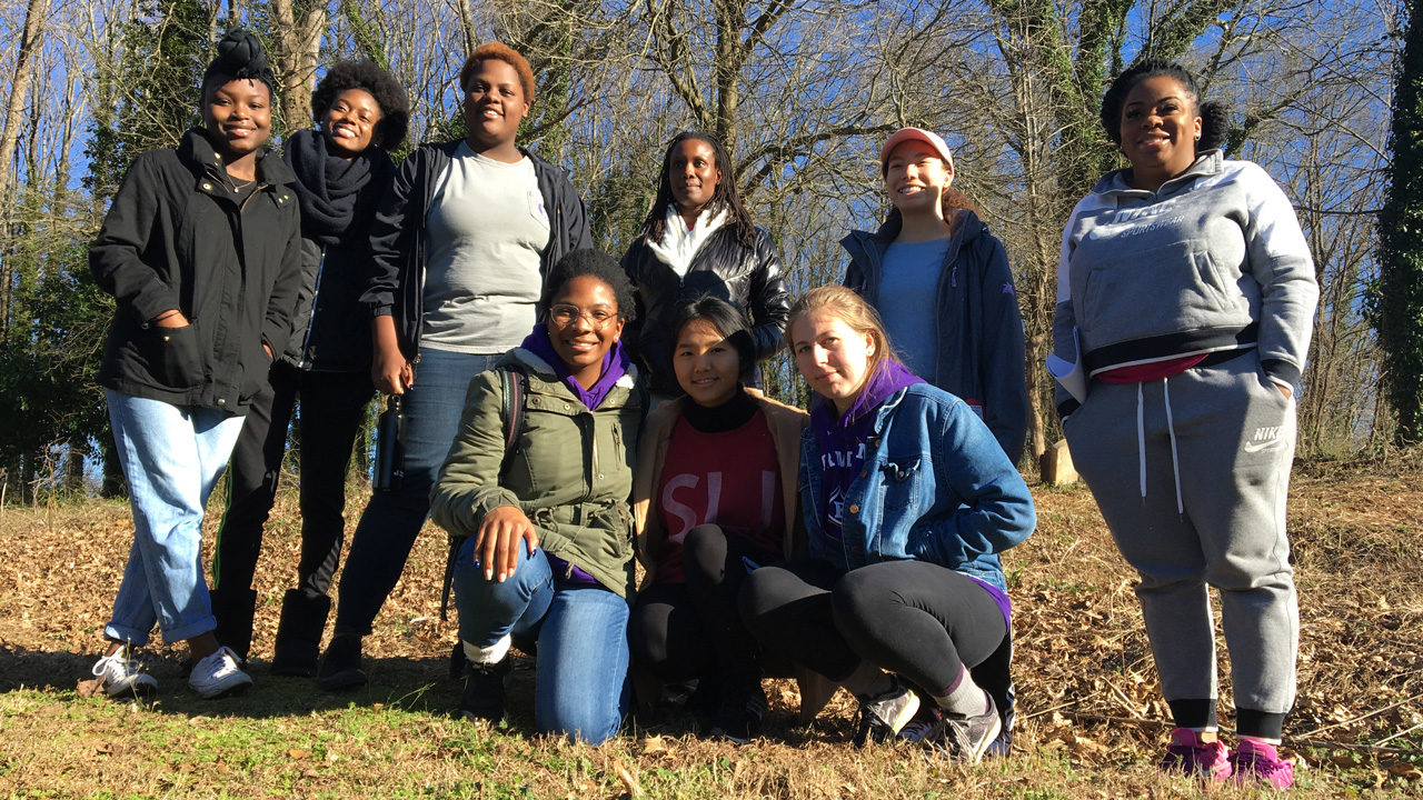 A group of student smile after engaging in service at the Brutontown cemetery.