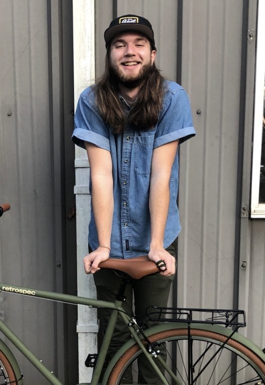 Student Jason Roberts stands with his bicycle