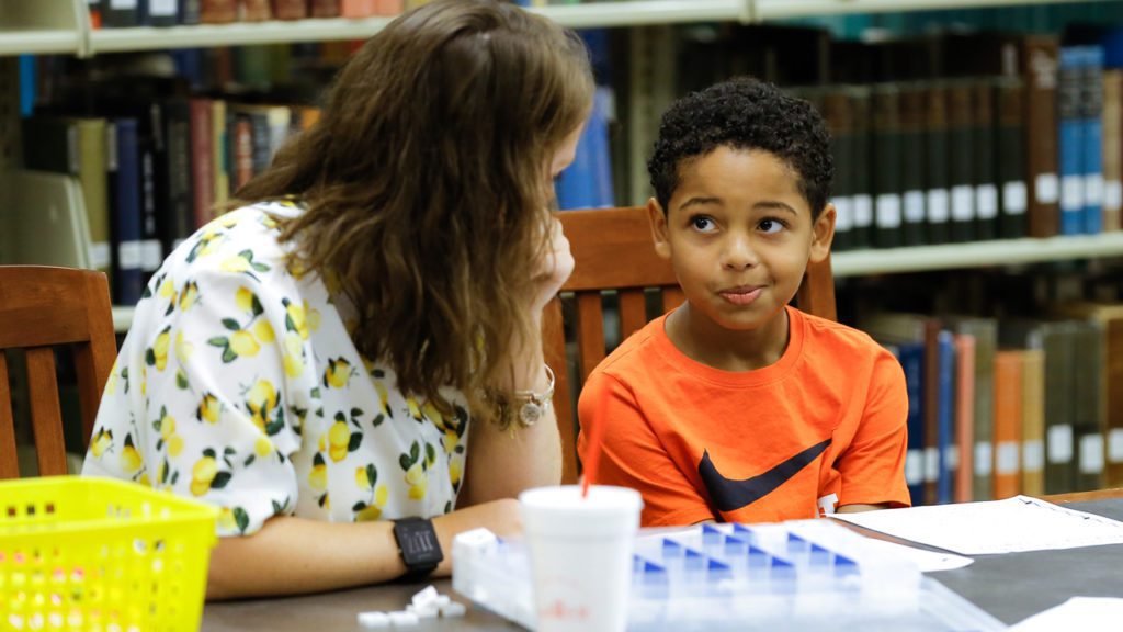 Student teacher working with elementary school child
