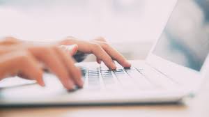 Hands typing on a laptop