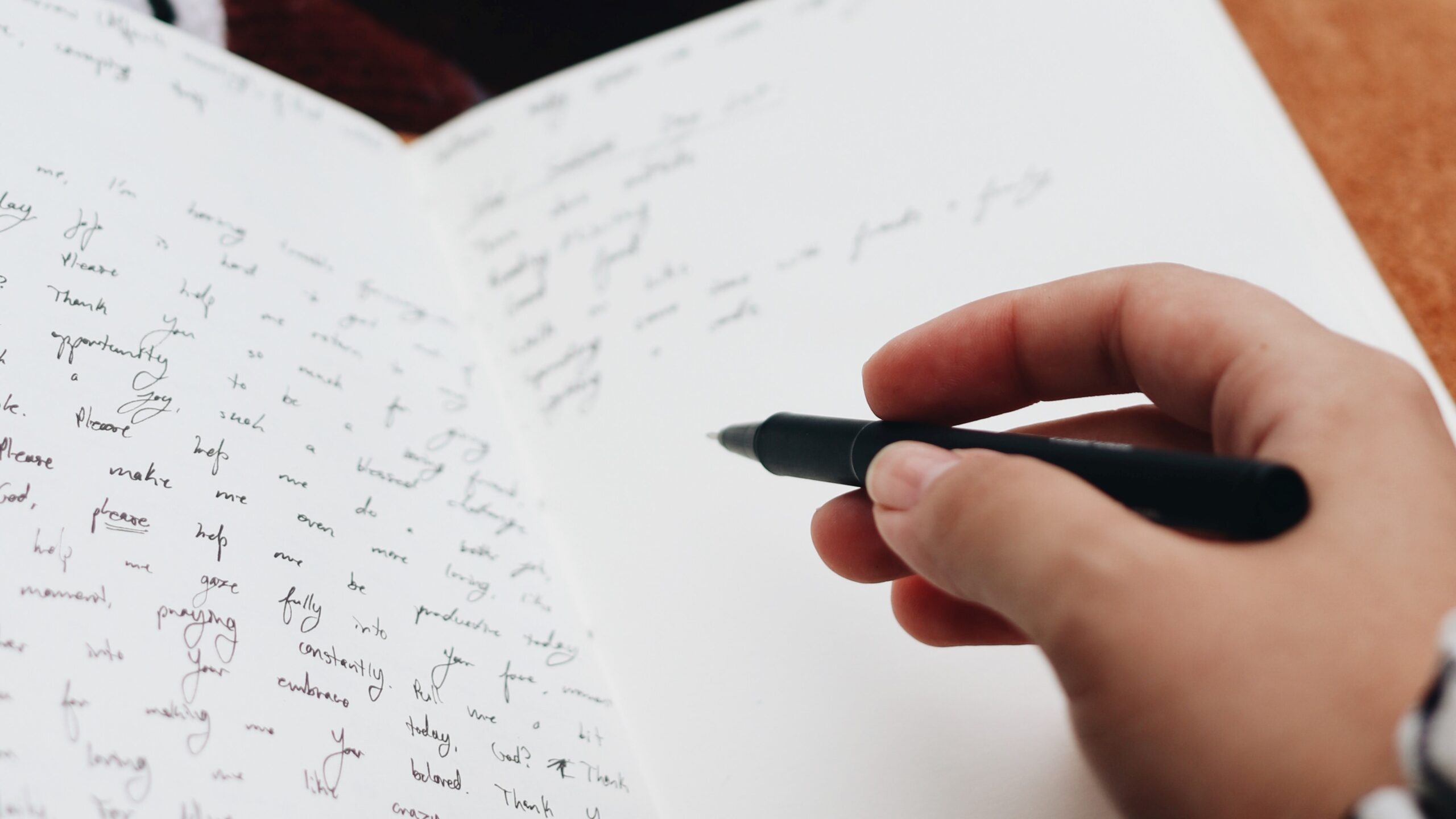 A person's hand writing on a piece of paper.