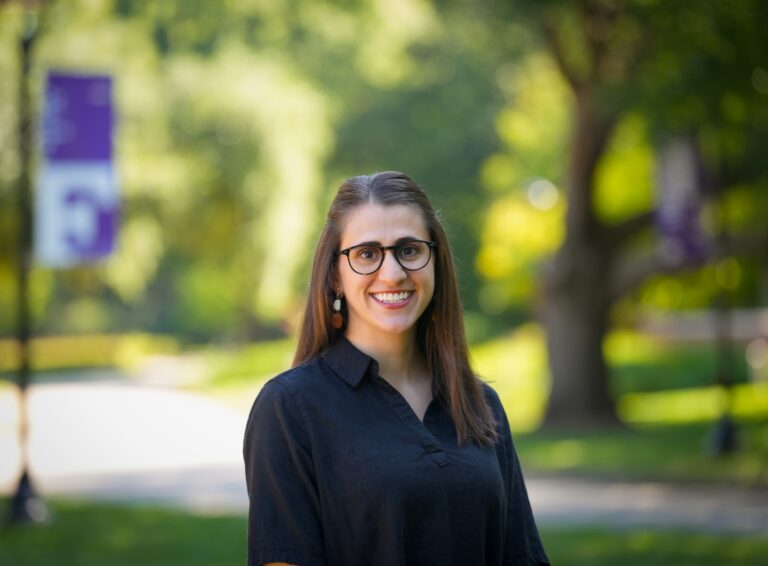 woman with brown hair, glasses, and black shirt