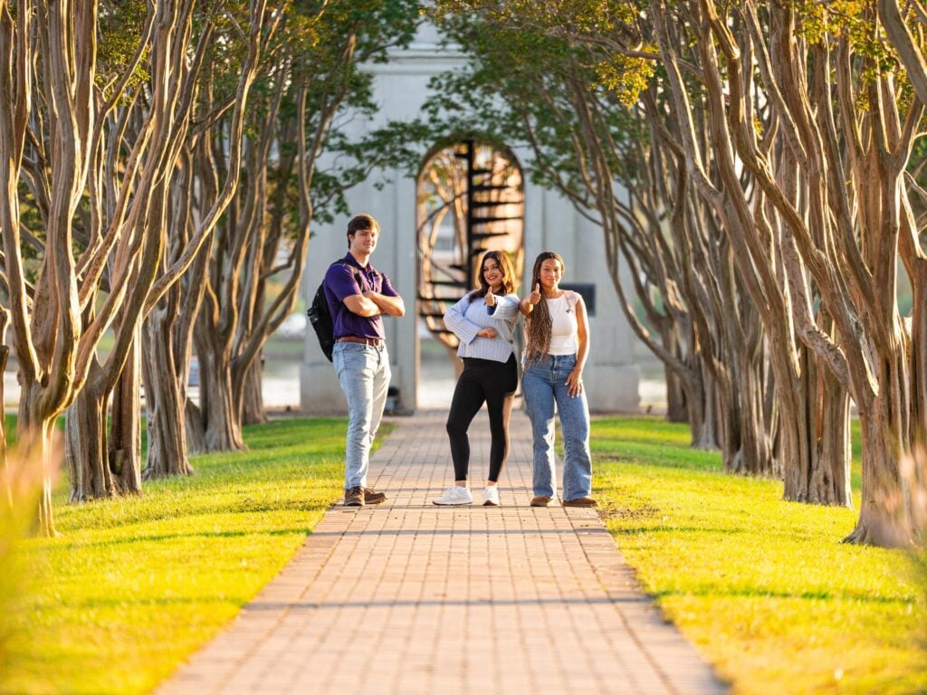Students giving thumbs up in front of the bell tower