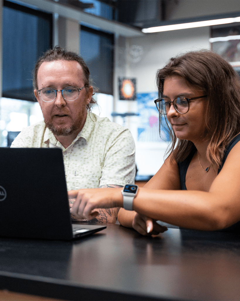 Faculty and student working through project on laptop