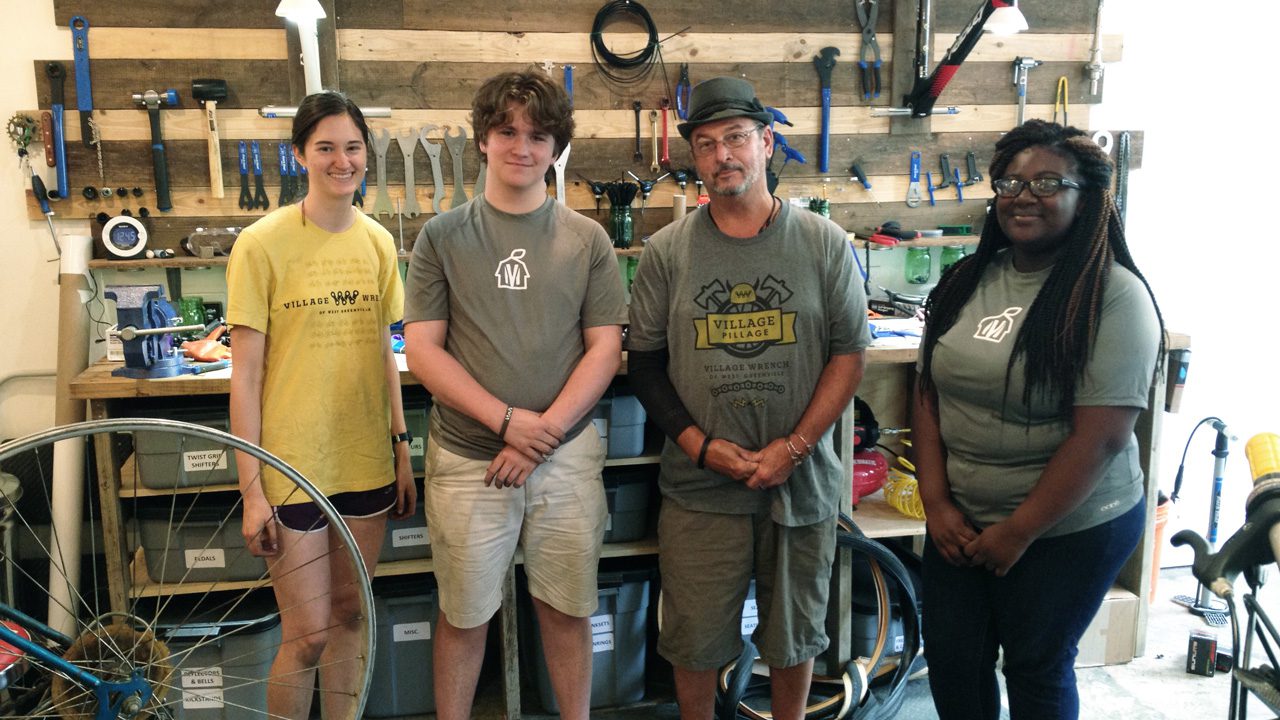 Summer Student Fellow <strong>Lauren Prunkl ’18</strong> (left), shown with the high school students and the bike mechanic she worked with during the summer of 2018 at The Village Wrench.