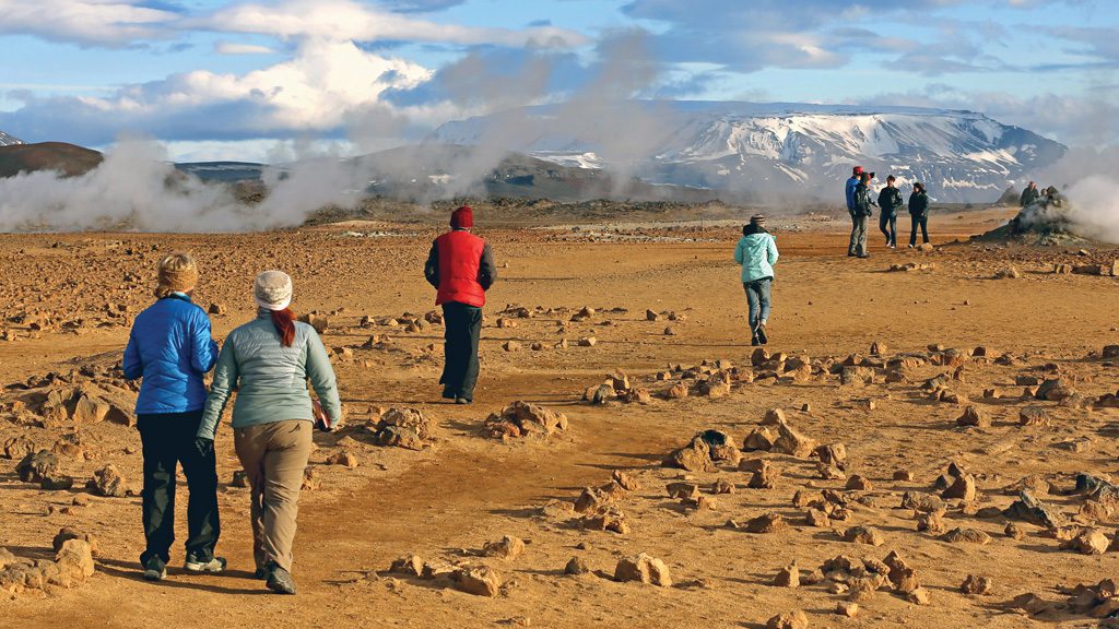 Students walking along geysers and stones