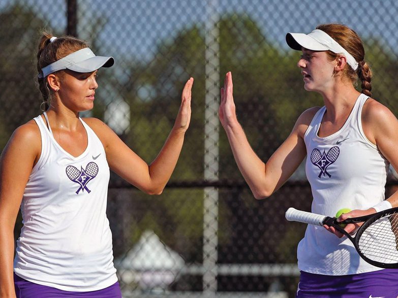 Two Furman tennis players high five
