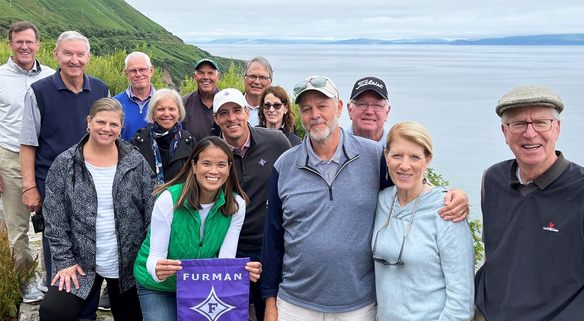 An alumni trip to Ireland in July. Associate Professor and Chair of Health Sciences Natalie The ’03 holds a Furman banner in front with Men’s Head Golf Coach Matt Davidson ’04 behind her.