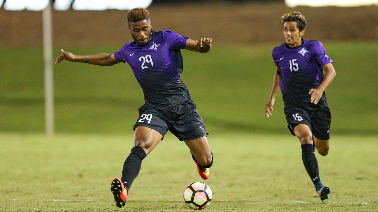 Furman students playing soccer, one student is preparing to kick the ball