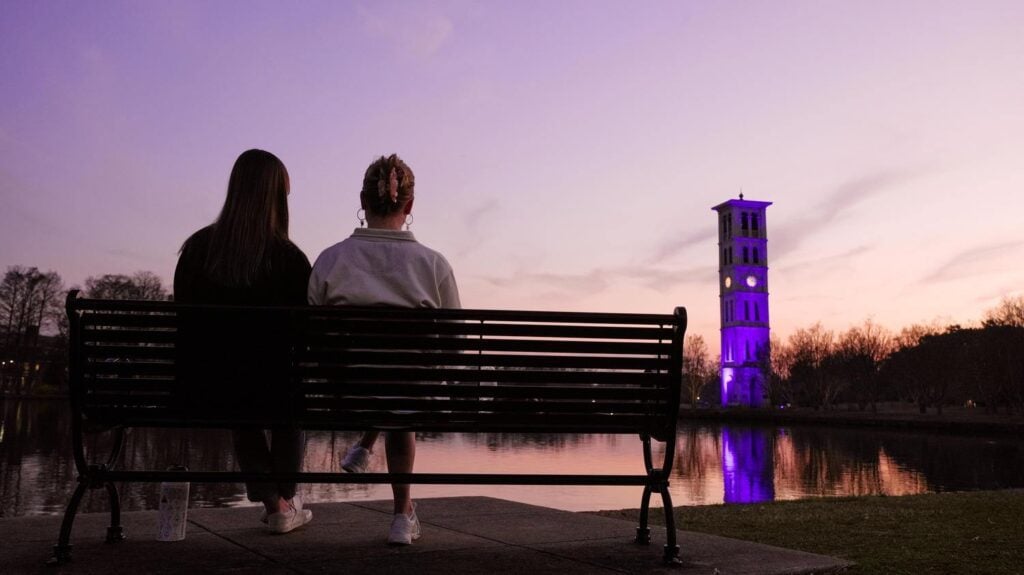 Students on bench watching sunset