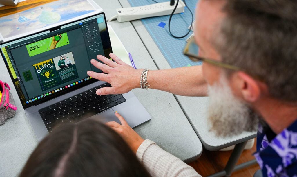 MASD professor reviews student's work on screen