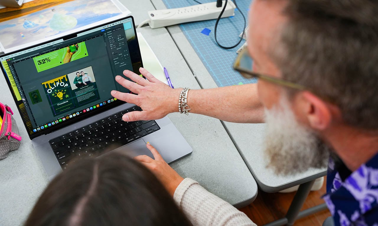 MASD professor reviews student's work on screen